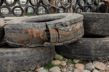 Pile of old tires with one of them having a large crack in it