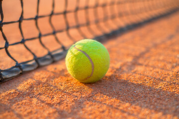 Tennis ball and net. Ground court for tennis. Sports equipment for an active lifestyle. Ball and court as a background. Postcard, background, wallpaper.
