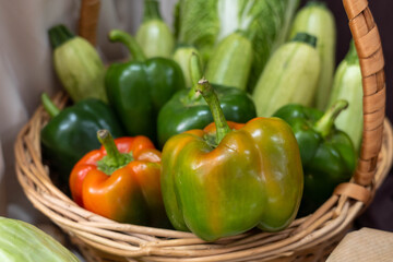 Colorful assortment of fresh vegetables including bell peppers, zucchini, and leafy greens arranged in a woven basket, showcasing vibrant colors and natural textures for healthy eating