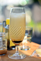 Iced coffee latte served in elegant glass on wooden table