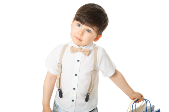 Cute boy in bow tie and suspenders holding shopping bags