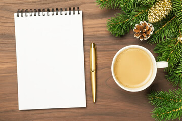 A winter composition with coffee, a blank notebook, and conifers. The perfect backdrop with a notebook layout for taking stock and setting New Year's goals.