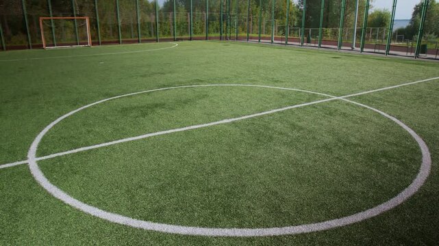 High angle shot of white circle drawn in center of football pitch