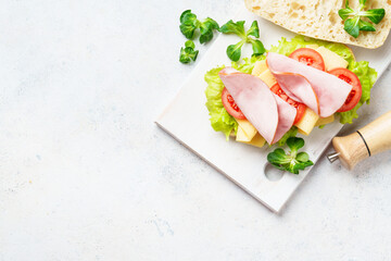 Ciabatta sandwich with lettuce, cheese, tomatoes and ham.