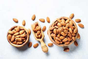 Almond nuts in wooden bowl at white background.
