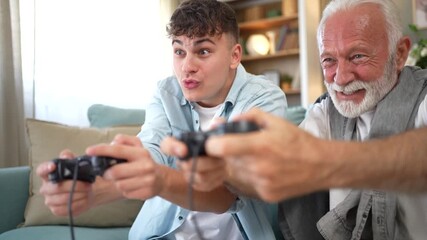 Grandfather and grandson playing video games together at home - Powered by Adobe