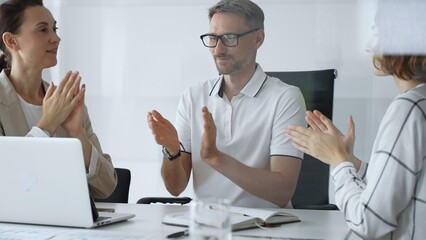Professional team applauding, celebrating collaborative success and recognizing outstanding performance during corporate meeting, expressing shared workplace achievement. Business people concept