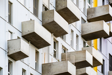 Modern residential building with projecting concrete balconies and minimalist geometric design emphasizing urban architectural rhythm