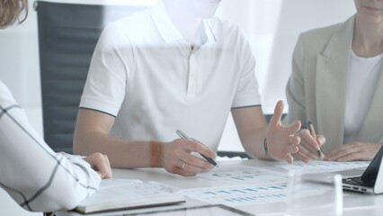 Professional team analyzing financial charts, working together in sleek workspace, strategizing company performance with collaborative energy and shared insights, close up