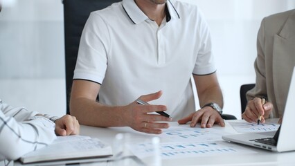 Professional team analyzing financial charts, working together in sleek workspace, strategizing company performance with collaborative energy and shared insights, close up