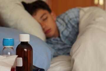 Children's health and medicine. Children's medicine bottles in the foreground and a sick child