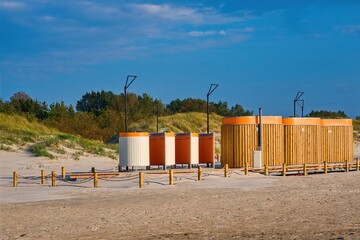 Modern changing rooms on sandy beach. Beach facilities near sand dunes.