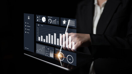 A business professional engages with a futuristic digital screen showcasing various graphs and analytics, emphasizing modern data interaction in a corporate setting. Impute
