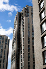 Sustainable urban architecture with modern residential buildings and large windows, promoting eco friendly design, energy efficiency, and green urban development under a clear blue sky