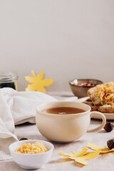 Autumn tea in a cup with apple croutons on a plate on the table vertical view