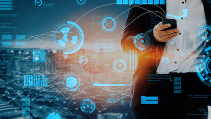 A business professional stands in a modern urban setting, using a smartphone and surrounded by digital data visualization. Ideal for themes of technology and innovation. Xenic