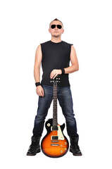 A rock 'n' roller guy stands at full height with a guitar in his hands.