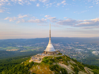 Jested Mountain Hotel glows in the evening light, perched atop a hill in Liberec. This modern architectural marvel stands as a TV transmitter, offering panoramic views of the landscape.