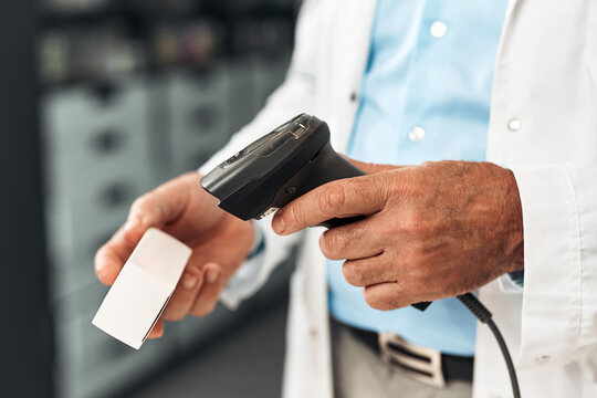 Senior pharmacist scans medicine package at checkout counter