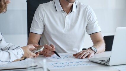 Professional team analyzing financial charts, working together in sleek workspace, strategizing company performance with collaborative energy and shared insights, close up