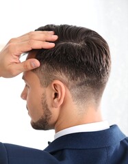 Fototapeta premium Man in suit, back view, adjusting hair