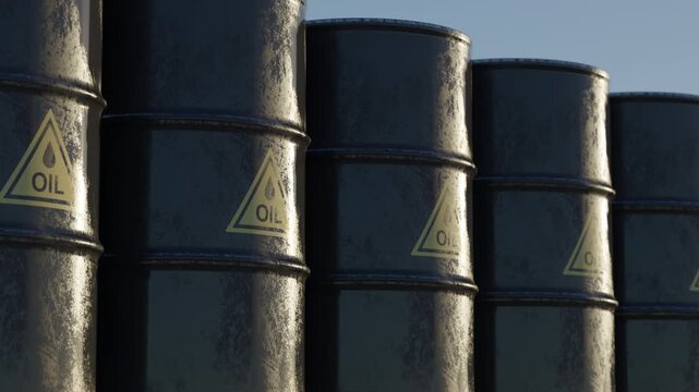 Row of black oil barrels with warning symbols under dramatic sky. Concept of global energy shortage, fuel crisis, dependence on fossil fuels and growing oil prices.