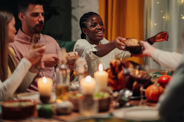 Friends sharing food, celebrating thanksgiving dinner together
