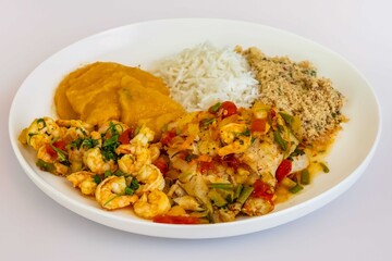 Brazilian moqueca capixaba is a typical dish from Espírito Santo, Brazil, with sea fish and shrimp, cooked in a clay pot and accompanied by white rice, pirão and farofa.