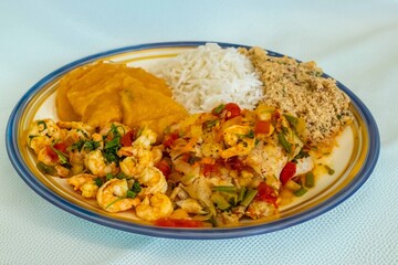 Brazilian moqueca capixaba is a typical dish from Espírito Santo, Brazil, with sea fish and shrimp, cooked in a clay pot and accompanied by white rice, pirão and farofa.
