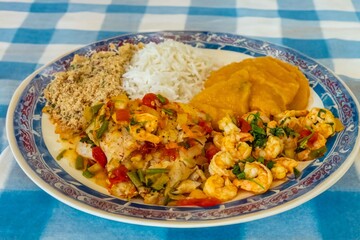 Brazilian moqueca capixaba is a typical dish from Espírito Santo, Brazil, with sea fish and shrimp, cooked in a clay pot and accompanied by white rice, pirão and farofa.
