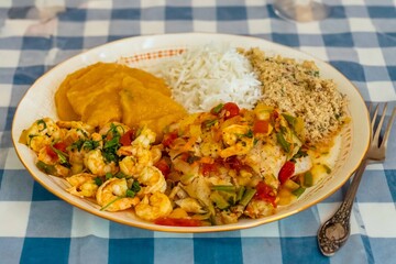 Brazilian moqueca capixaba is a typical dish from Espírito Santo, Brazil, with sea fish and shrimp, cooked in a clay pot and accompanied by white rice, pirão and farofa.