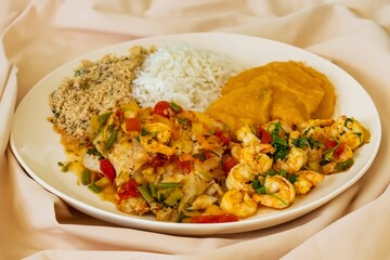 Brazilian moqueca capixaba is a typical dish from Espírito Santo, Brazil, with sea fish and shrimp, cooked in a clay pot and accompanied by white rice, pirão and farofa.