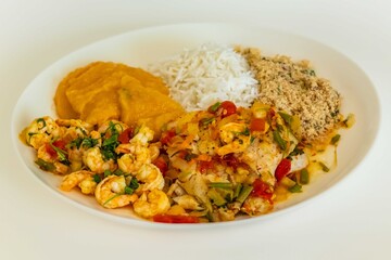 Brazilian moqueca capixaba is a typical dish from Espírito Santo, Brazil, with sea fish and shrimp, cooked in a clay pot and accompanied by white rice, pirão and farofa.