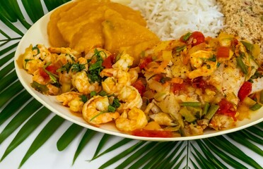 Brazilian moqueca capixaba is a typical dish from Espírito Santo, Brazil, with sea fish and shrimp, cooked in a clay pot and accompanied by white rice, pirão and farofa.