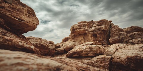 A low angle shot of large rock formations under a cloudy sky in a desert landscape setting outdoors