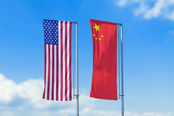 United States and China national flags waving on tall poles against blue sky, international relations and diplomacy concept.