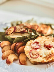 Toast with Camembert cheese, omelette, plum and arugula
