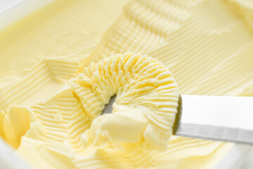 Margarine on knife in a plastic box.