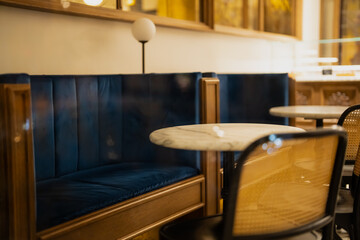 Modern cafe interior with blue velvet seating, marble tables and warm lighting, elegant restaurant design showcasing hospitality style, luxurious atmosphere and refined contemporary decor
