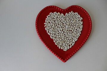 Dried white beans on a beautiful heart-shaped plate