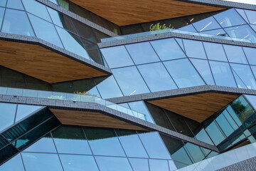 Modern architectural design featuring angular glass facades and wooden accents, showcasing...