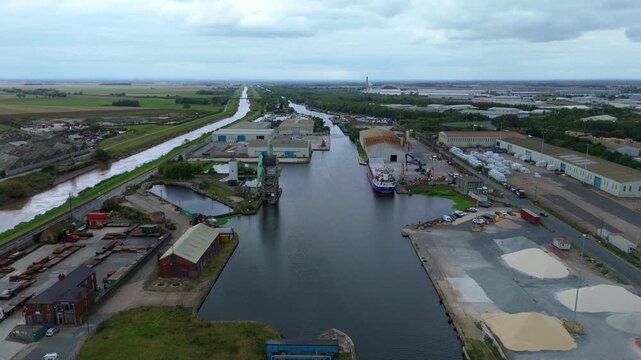 Aerial drone view of busy shipping port, industrial buildings and wharfs for loading and unloading cargo ships and tankers near Goole, United Kingdom