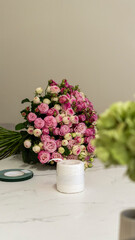 A bouquet of pink roses lies on a table in a flower shop