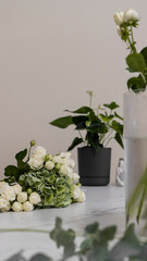 A white and green bouquet lies on the counter in a flower shop