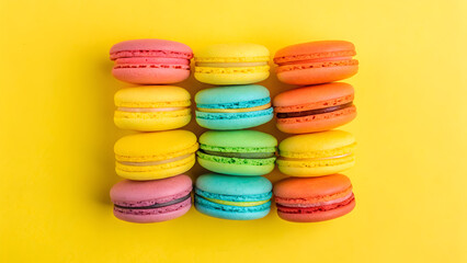 Fototapeta premium A rainbow-colored macaron arrangement on a bright yellow background.
