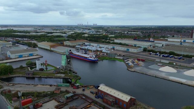 Aerial drone view of busy shipping port, industrial buildings and wharfs for loading and unloading cargo ships and tankers near Goole, United Kingdom
