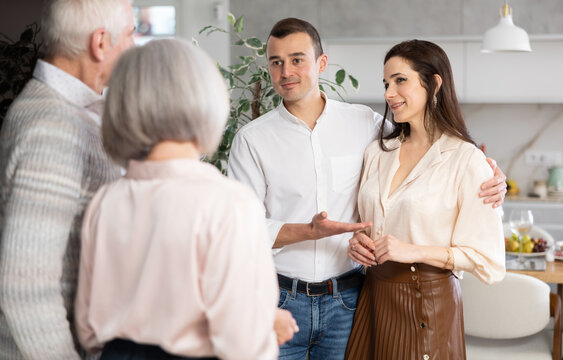 Adult man introduces his beloved girlfriend to elderly parents. Perplexed senior spouses are upset by new acquaintances, they look disapprovingly at their son and his female partner - Powered by Adobe