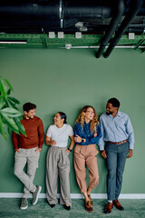 Diverse business professionals sharing a laugh, networking, and standing together in a modern...