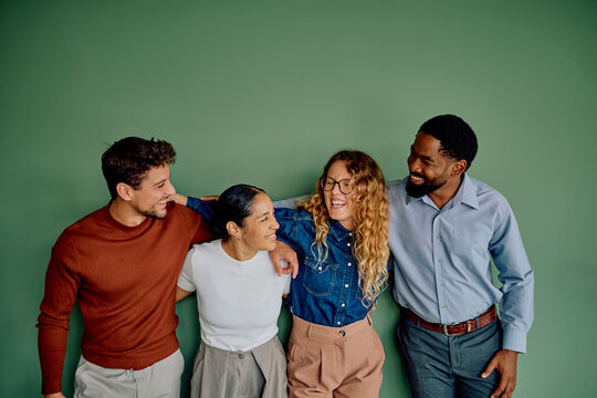 Diverse group of happy friends laughing and standing together, demonstrating unity, friendship, and collaboration