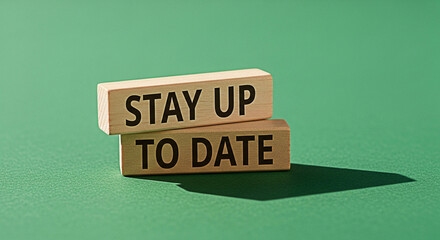 Stay up to date message on wooden blocks against a green background representing current information